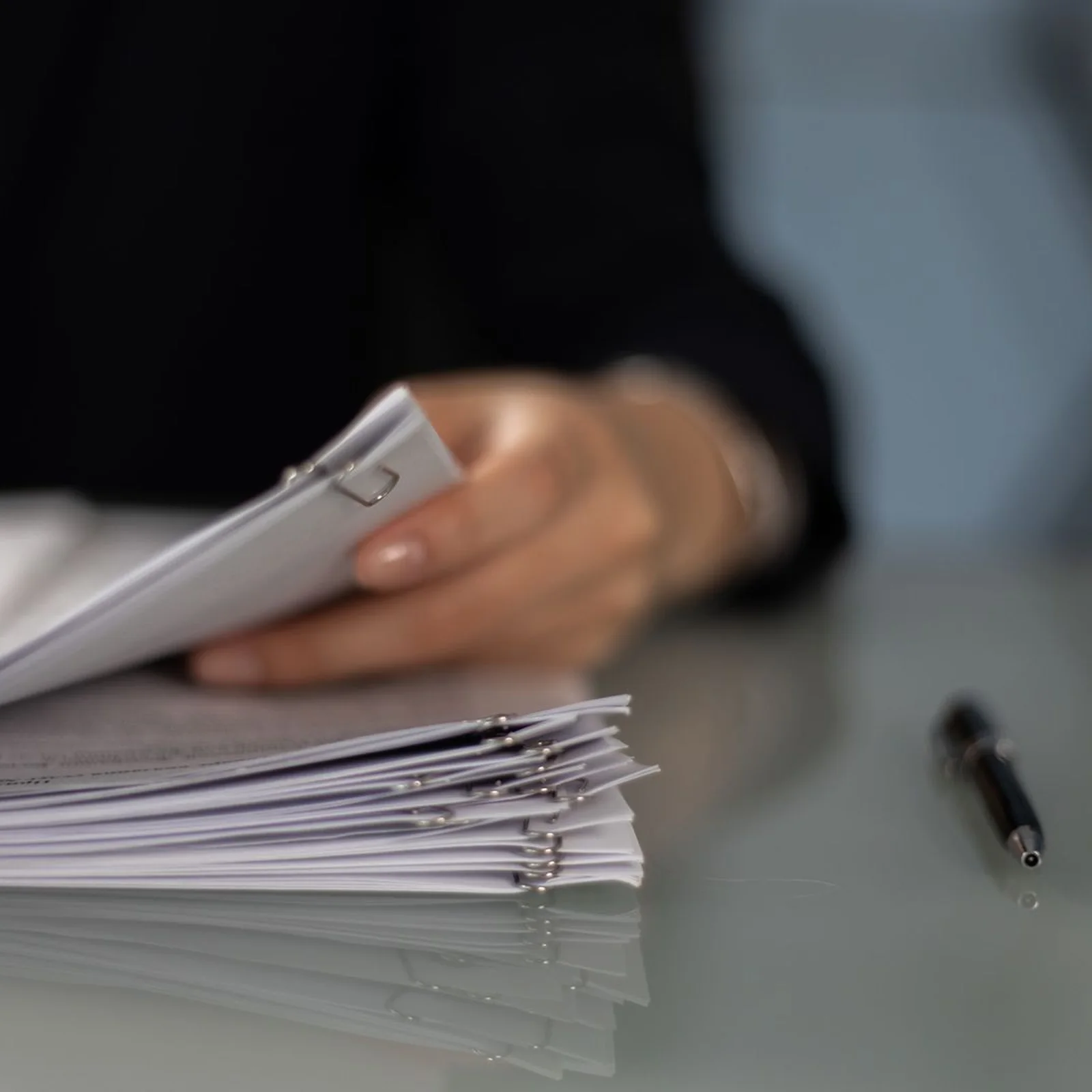 Documents on a desk with a pen.